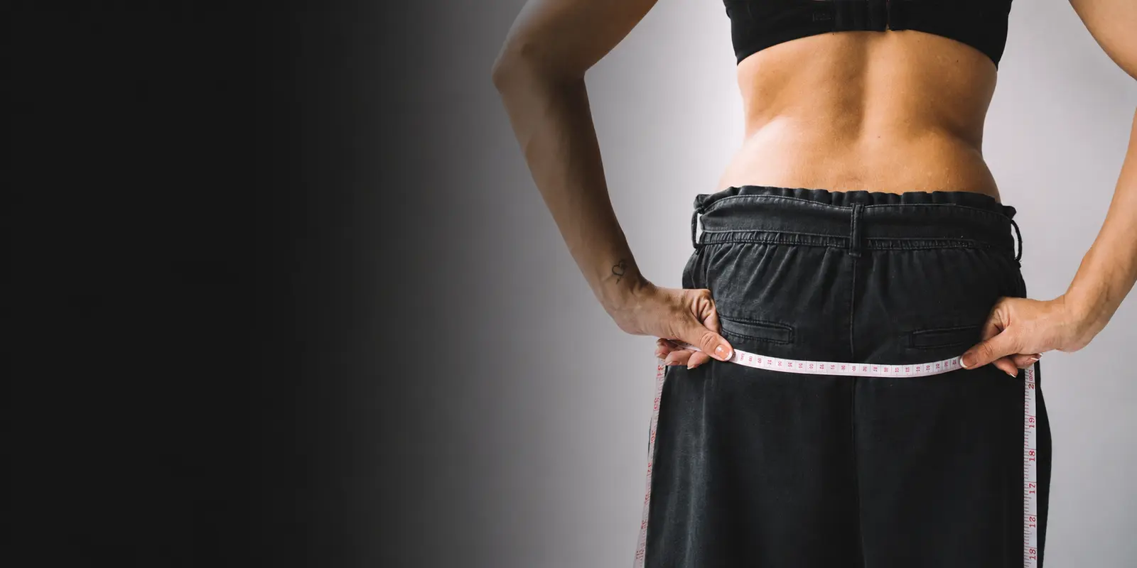 Fita métrica medindo a cintura, usada no cálculo do percentual de gordura corporal