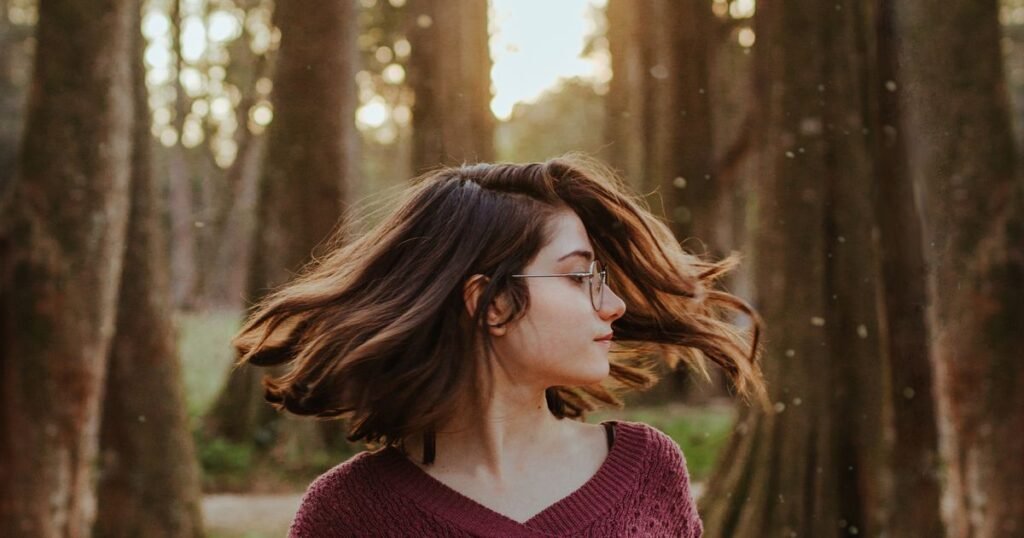 Mulher com cabelo saudável e volumoso em movimento, ao ar livre