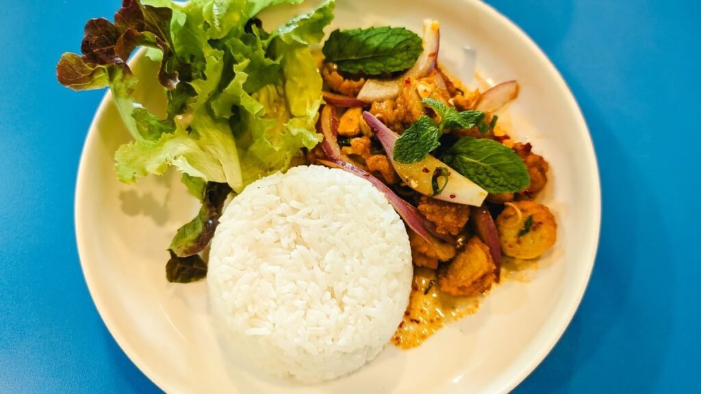 Prato com arroz, frango e salada visto de cima