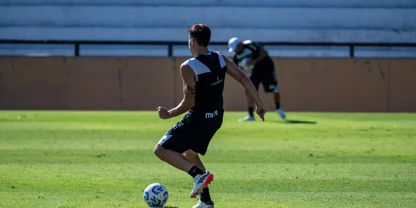 Jogador de futebol treinando com bola em campo, nutricionista esportivo para futebol no Rio de Janeiro